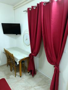 Zimmer mit einem Tisch und einem roten Vorhang in der Unterkunft Java apartments - S & J in Dobrota