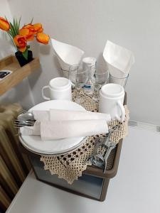 ein Tablett mit Teller und Tassen auf einem Tisch mit Blumen in der Unterkunft Java apartments - S & J in Dobrota