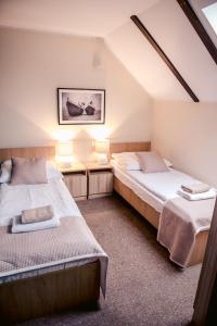 a attic bedroom with two beds and two lamps at Apartamenty Riffe 99 m od najpiękniejszej plaży w Polsce in Rewa