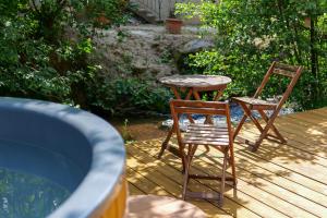 2 sillas y una mesa en una terraza de madera en Les Jardins du Nideck en Oberhaslach