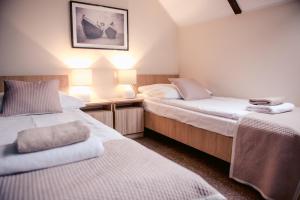 two beds in a room with two lamps and two bedsvisor at Apartamenty Riffe 99 m od plaży w centrum Rewy in Rewa