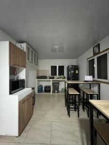 una cocina con electrodomésticos blancos, mesa y sillas en Rockxy HOSTEL BY JR en Providencia