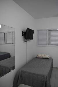 ein Schlafzimmer mit einem Bett und einem TV an der Wand in der Unterkunft Apartamento próximo a Canção Nova in Cachoeira Paulista