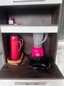 a pink blender and a pink mug in a drawer at Residência Shalom in Presidente Figueiredo