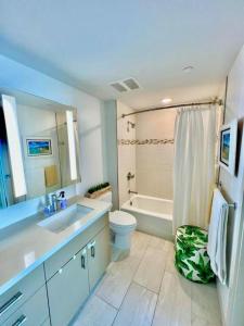 La salle de bains est pourvue d'un lavabo, de toilettes et d'une baignoire. dans l'établissement Luxury Oasis Residence, à Honolulu