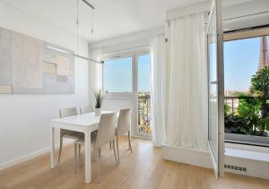 un comedor blanco con una mesa y sillas blancas en Magical Modern Apartment Eiffel Tower, Paris The Million Dollar View, en París