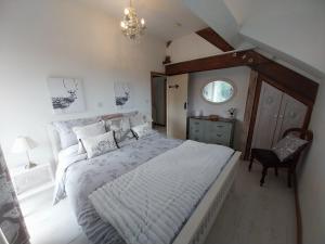 a bedroom with a large bed and a chair at Meadowbeck Holiday Cottages in Whitby