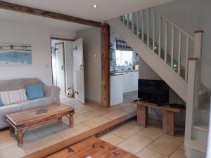 een woonkamer met een bank en een tv bij Meadowbeck Holiday Cottages in Whitby