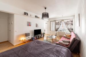 a living room with a bed and a tv at Central Studio Apartment in Pori