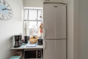 una nevera blanca en una cocina con reloj en la pared en Central Studio Apartment, en Pori