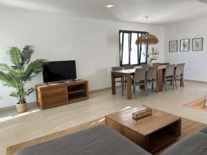 a living room with a television and a dining room at Villa Son Blanc 5 in Sa Caleta