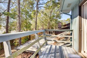 a wooden deck on the side of a house with trees at Shalimar Townhome with Screened Porch 6 Mi to Beach in Shalimar