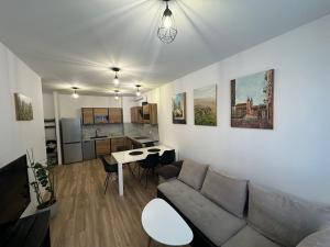 een woonkamer met een bank en een keuken bij Kotlina Kłodzka - Apartament na Letniej in Kłodzko