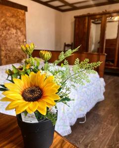 un vase noir avec une fleur jaune sur une table dans l'établissement Antico Casolare da Francesca, à Porto Viro