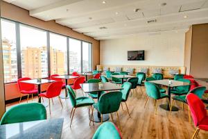 un restaurante con mesas, sillas y ventanas en Hampton By Hilton Santiago Las Condes, en Santiago