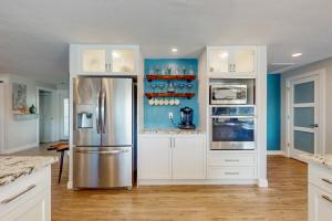 珊瑚角的住宿－Starry Sands，厨房配有白色橱柜和不锈钢冰箱