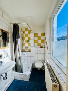 a bathroom with a tub and a toilet and a sink at TheCrossing Bed & Breakfast in Hausen im Tal