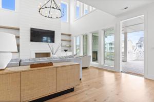 a living room with a couch and a tv at 25 Cumberland - Canal front with dock, Custom home finishes in Ocean Isle Beach