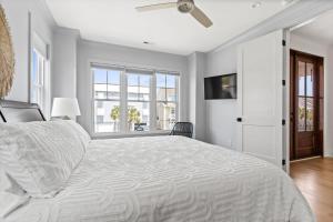 a bedroom with a large bed with a ceiling fan at 25 Cumberland - Canal front with dock, Custom home finishes in Ocean Isle Beach