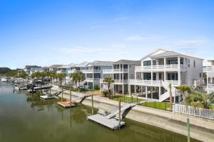 a row of apartment buildings next to a marina at 25 Cumberland - Canal front with dock, Custom home finishes in Ocean Isle Beach