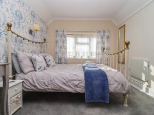 um quarto com uma cama com papel de parede azul e branco em Molly's Bit em Chipping Norton