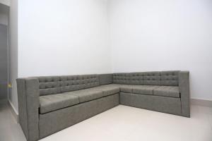 un sofá en una habitación con una pared blanca en Hotel Victoria Royal, en Puri