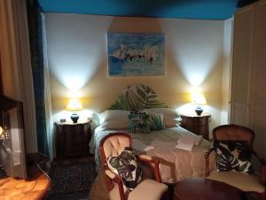 ein Schlafzimmer mit einem Bett mit zwei Stühlen und zwei Lampen in der Unterkunft 49 Le Contesse Ide in Meolo
