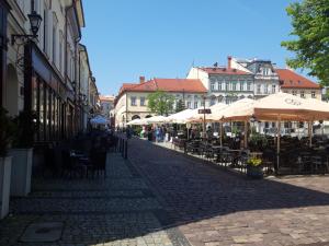 an empty street with tables and chairs and umbrellas at Apartamenty Orkana in Bielsko-Biała