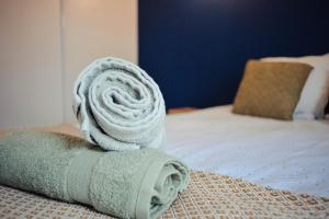uma toalha enrolada em cima de uma cama em Charlie et la Chocolaterie- Parking- Clim- CentreVille em Montauban