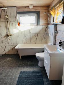 ein Badezimmer mit einer Badewanne, einem WC und einem Waschbecken in der Unterkunft Maja Matsalu luhal 