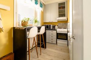 una cocina con armarios blancos y una barra con taburetes en Studio: Alex’s secret!, en Pori