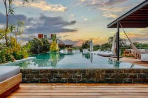a swimming pool in a backyard with a resort at 5 Star NEW Luxury Condo with Cenote and Infinity Pool in Tulum