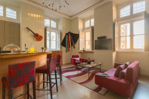 a living room with a bar and red chairs at Serenata Hostel Coimbra in Coimbra