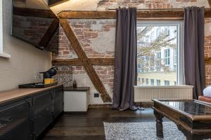 a living room with a brick wall and a window at Kurpiai - Suites & SPA in Klaipėda