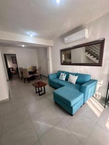 uma sala de estar com um sofá azul e uma mesa em Porteño Abode em Veracruz