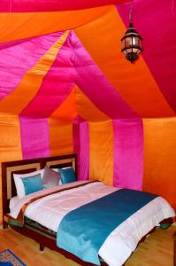 a large tent with a bed in a room at Rainbow Desert Camp in Merzouga