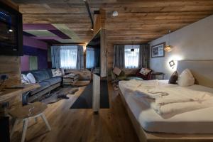 um quarto com uma cama grande e uma sala de estar em Alpine Residence Villa Adler em San Vigilio Di Marebbe
