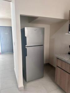 uma cozinha com um frigorífico de aço inoxidável num quarto em Porteño Abode em Veracruz