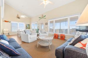 a living room with couches and a table and chairs at A Coconut Hut Brunswick Vacation Rentals in Oak Island