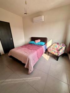 um quarto com uma cama e uma cadeira em Porteño Abode em Veracruz