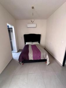 a bedroom with a bed with a purple blanket at Porteño Abode in Veracruz