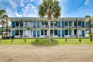 un gran edificio blanco con palmeras delante en Bells Marina & Fishing Resort - Santee Lake Marion by I95 - Family Adventure, Pets on Request!, en Eutawville