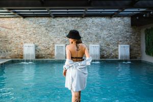 kobieta stojąca w wodzie obok basenu w obiekcie Bella Gramado Resort & Spa by Gramado Parks w mieście Gramado
