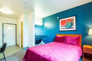 ein Schlafzimmer mit einem rosa Bett und einer blauen Wand in der Unterkunft The Vistas 119 Modern studio with full kitchen 1st floor great location in Sierra Vista