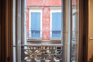 a view from a window of a building with blue doors at La perle de la République - Au coeur du centre historique in Montauban