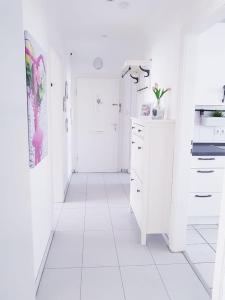 cocina blanca con suelo blanco y armarios blancos en Hannover City Suite en Hannover