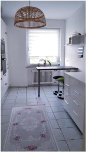 a white kitchen with a table and a window at Hannover City Suite in Hannover