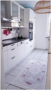 una cocina con armarios blancos y una alfombra en el suelo en Hannover City Suite en Hannover