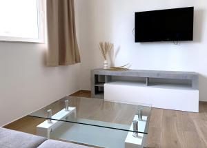 a living room with a tv and a glass coffee table at Miami Apartments in St. Julianʼs