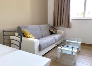 a living room with a couch and a glass table at Miami Apartments in St. Julianʼs